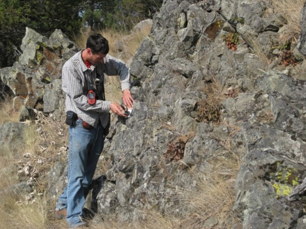 Geologist Kaleb Scarberry, measuring foliation in a basalt flow