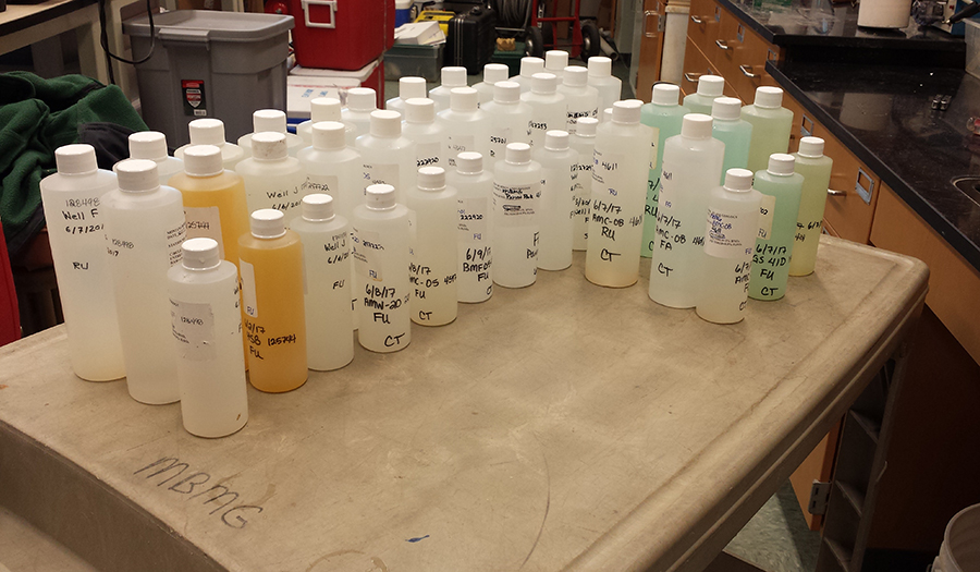 Water sample bottles showing various colors from Butte Mine Flooding sample sites
