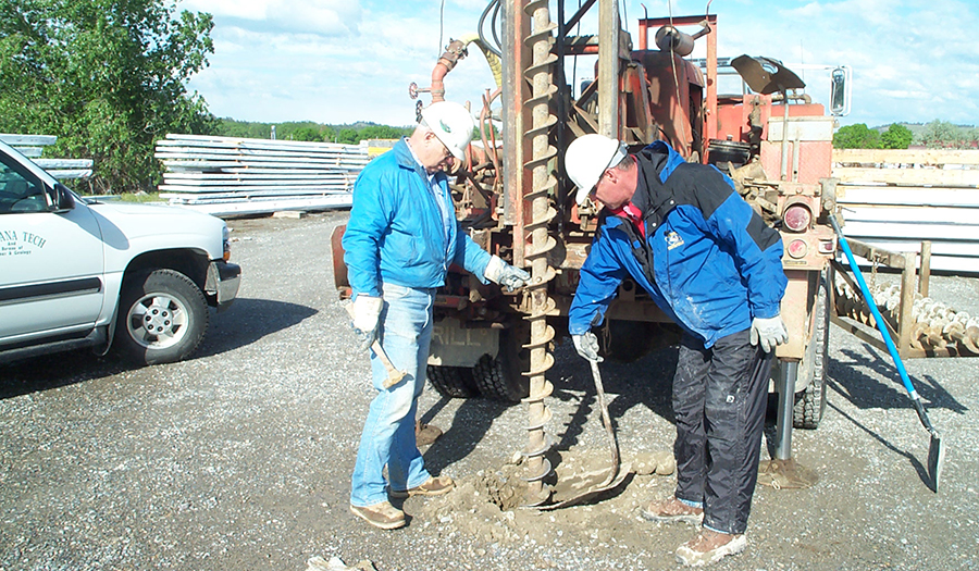 MBMG driller Fred Schmidt (left) and EPA project manager Roger Hoogerhide adding auger to drill string